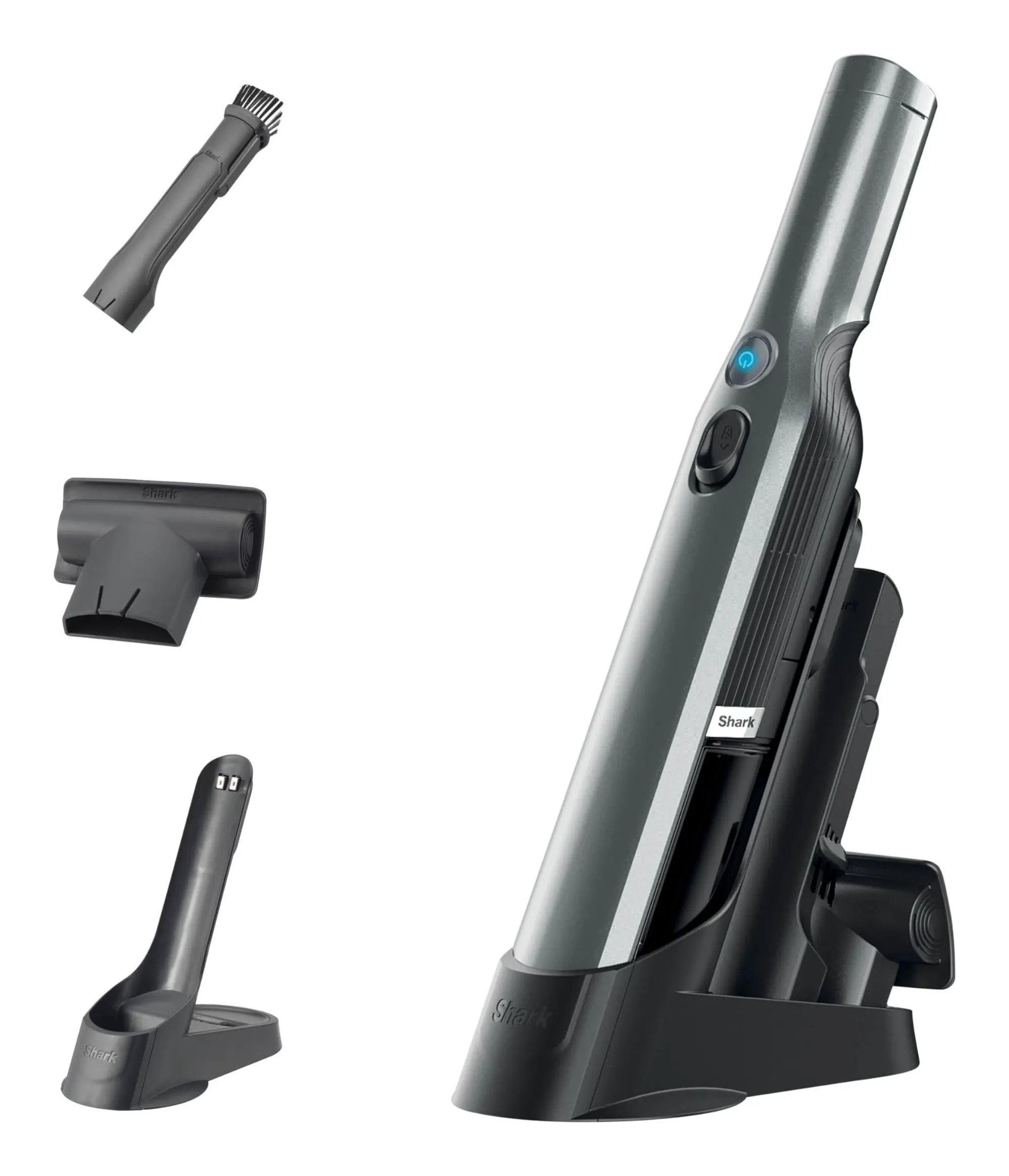 Shark WandVac cordless handheld in grey standing upright on its black charging base, with a crevice tool, a pet multi tool and a spare base beside it